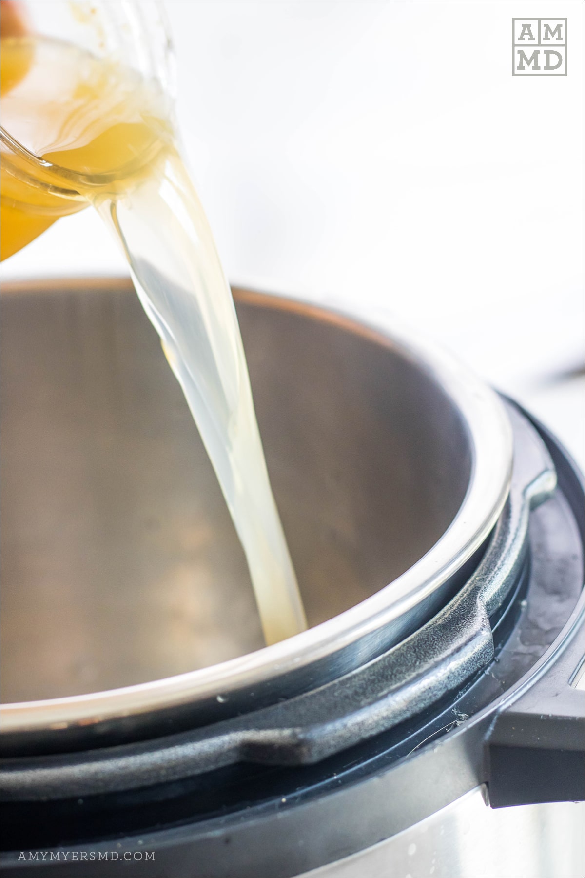 6 cups of bone broth being into a sauce pan containing AIP-friendly ingredients for a butternut squash soup 