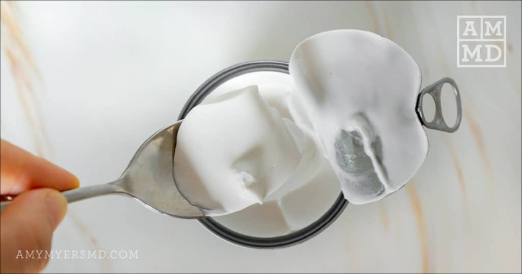 Spoon scooping a dallop of coconut cream used for AIP-friendly caramel sauce